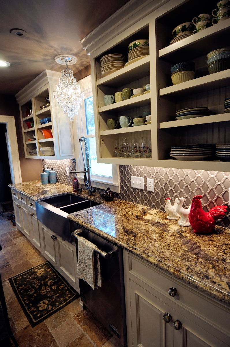 Stainless farmhouse sink set into a finished kitchen countertop.