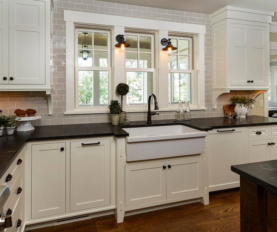 White apron-front sink with custom cabinet detailing.